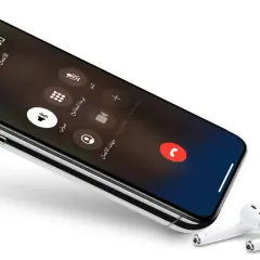 iPhone z włączonym wifi calling, ekran połączenia z Jane Appleseed. Obok leżą słuchawki AirPods.