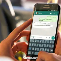 Dłoń trzyma smartfon z otwartym WhatsAppem, pokazując rozmowę. Dowiedz się, jak zainstalować WhatsApp.