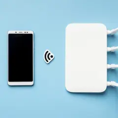 Smartfon i router Wi-Fi obok symbolu sieci. To pokazuje, jak działa hotspot.