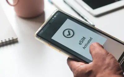Dłoń trzyma smartfon z aktywowanym eSIM. Dowiedz się, jak przenieść eSIM na inny telefon, by cieszyć się mobilnością.
