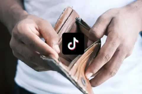 Puste ręce pokazują pusty portfel, a na nim logo TikTok. Chcesz oglądać **tiktok za darmo**?