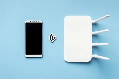 Smartfon i router Wi-Fi obok symbolu sieci. To pokazuje, jak działa hotspot.