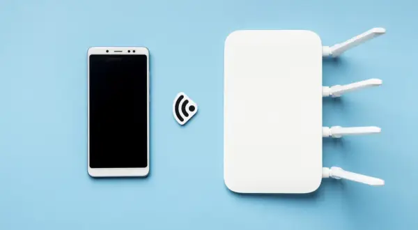 Smartfon i router Wi-Fi obok symbolu sieci. To pokazuje, jak działa hotspot.