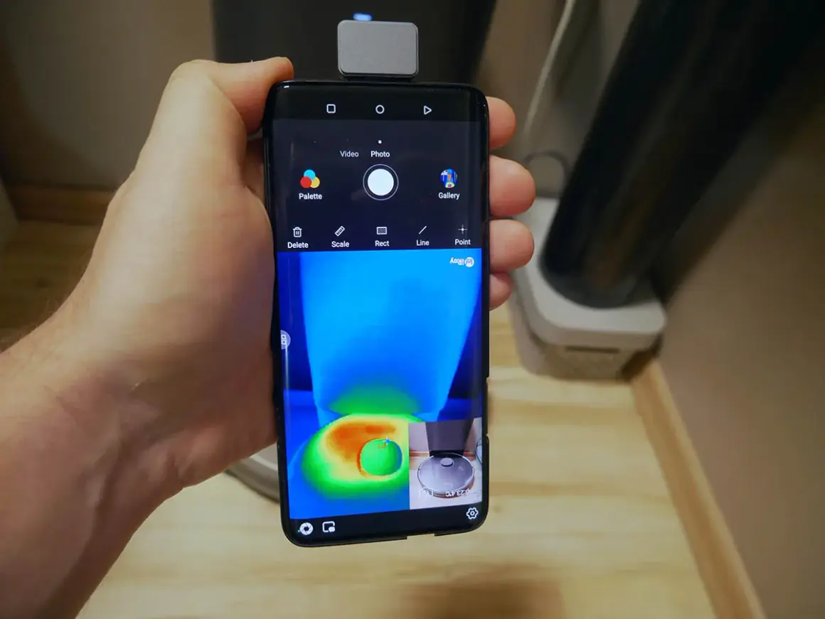Termowizja w telefonie pokazuje ciepło wydzielane przez robot sprzątający.