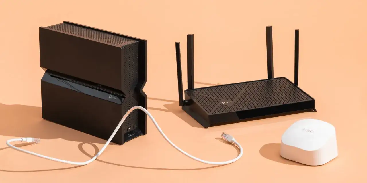 Dwa czarne routery TP-Link i biały eero stoją obok siebie na pomarańczowym tle.