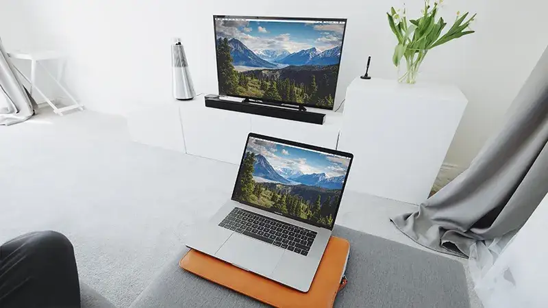 osoba rozwiązująca problem z połączeniem laptopa i telewizora