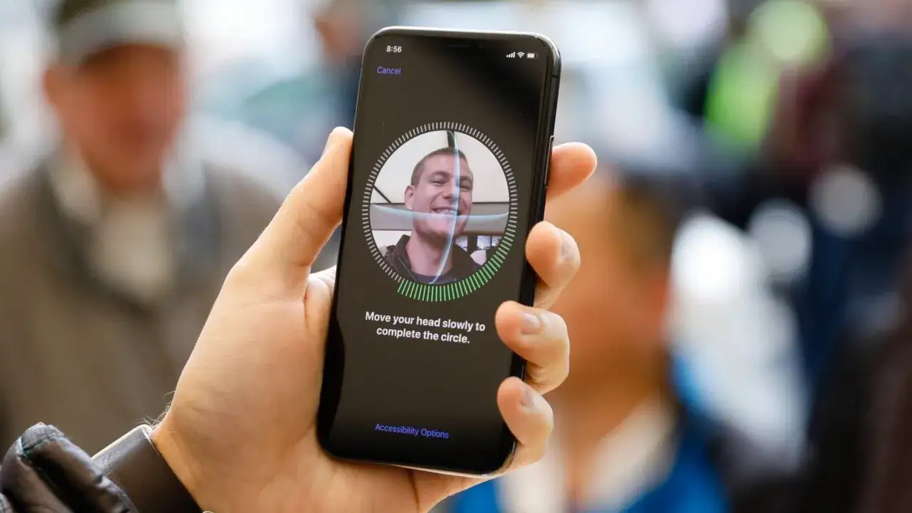 Ustawianie Face ID na iPhonie. Na ekranie widać twarz użytkownika i instrukcję 