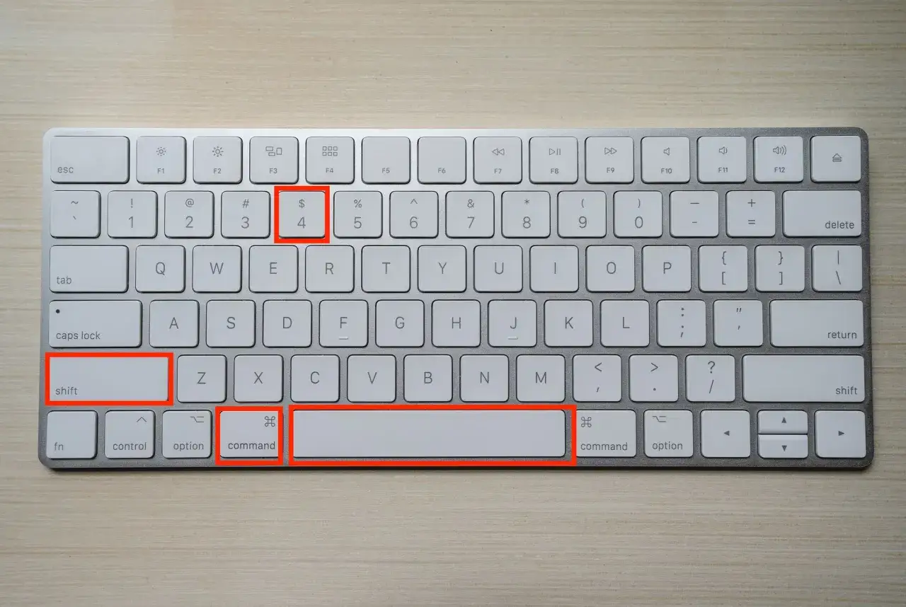 Klawiatura Mac z zaznaczonymi klawiszami: Shift, Command, 4. To skrót do zrobienia zrzutu ekranu.