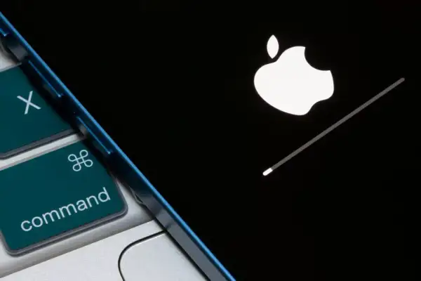 Klawiatura Mac z klawiszem Command i ekran iPhone'a z logo Apple i paskiem postępu. Dowiedz się, jak wyczyścić iPhone.