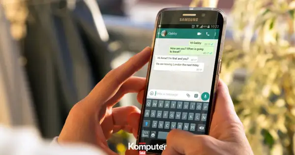 Dłoń trzyma smartfon z otwartym WhatsAppem, pokazując rozmowę. Dowiedz się, jak zainstalować WhatsApp.